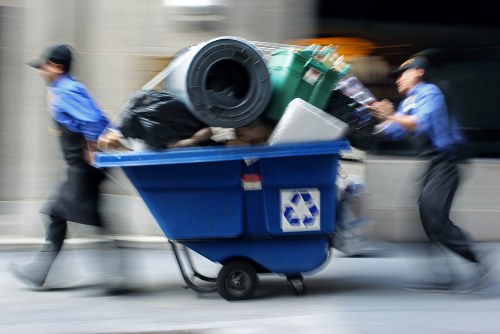 Collection crew securing a loaded skip onto a covered vehicle