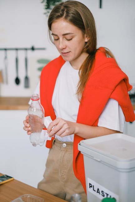 A large outdoor pile of mixed household rubbish includes numerous plastic containers, bottles, and cups in various colors such as white, blue, green, and pink, with some featuring labels and logos. Th